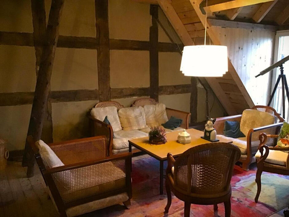 Stilvoll eingerichteter Aufenthaltsbereich mit historischen Fachwerkbalken, bequemen Sitzmöbeln und besonderem Mühlencharme.