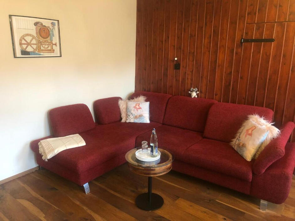 Wohnzimmer mit großer Eckcouch, Holzwand und stilvoller Einrichtung für entspannte Stunden in der Wassermühle Bruchmühlen.