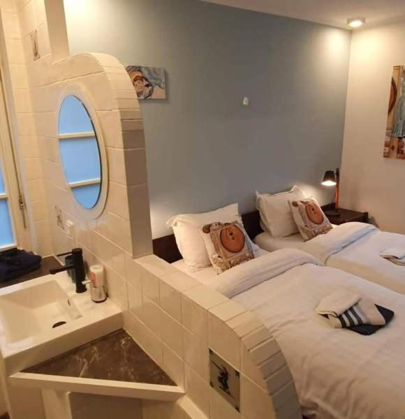 Stilvoll eingerichtetes Gästezimmer mit komfortablen Betten und offen integriertem Badezimmer – komfortable Übernachtung in der Wassermühle Bruchmühlen.