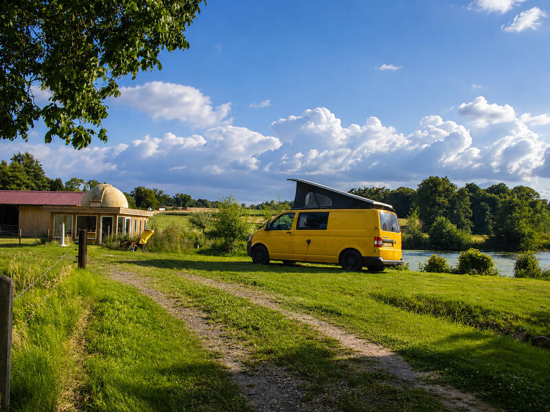 Wohnmobil auf einem naturnahen Stellplatz direkt am See der Bruchmühle – ideal für Camping und Erholung im Grünen.