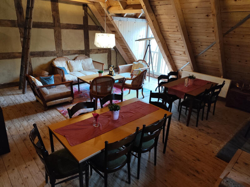 Rustikaler Aufenthaltsraum mit Sitzgruppen, Holzbalken und gemütlicher Atmosphäre für Gruppen und Gäste der Bruchmühle.